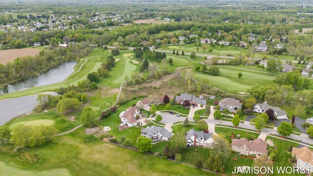 aerial view of residential area featuring a nearby body of water and a local golf course