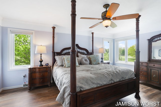 bedroom featuring dark wood-style floors, baseboards, crown molding, and a ceiling fan
