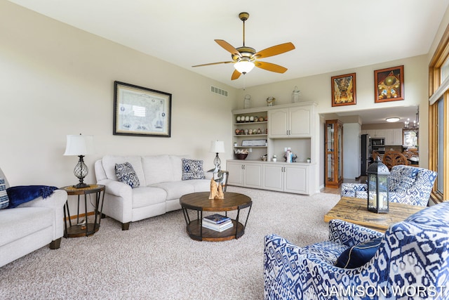 living room with light colored carpet and ceiling fan