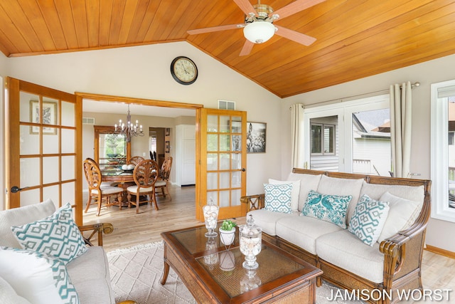 living room featuring lofted ceiling, plenty of natural light, light wood-style flooring, wooden ceiling, and a chandelier