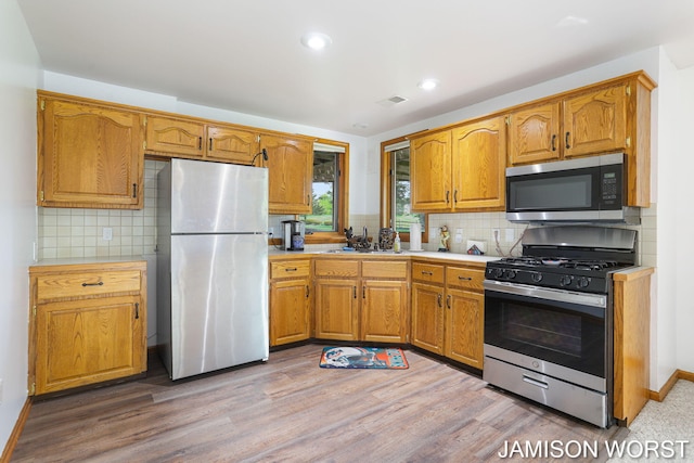 kitchen featuring stainless steel appliances, tasteful backsplash, light countertops, and recessed lighting