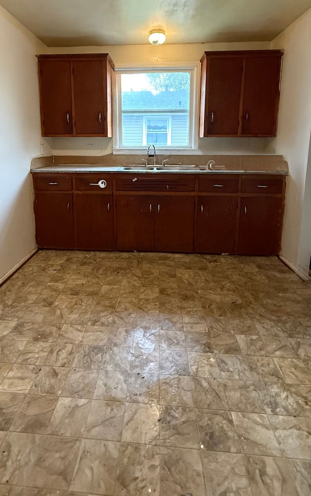 206 Frazier St, River Rouge, MI 48218 - kitchen featuring baseboards, a sink, light stone finish floors, and light countertops