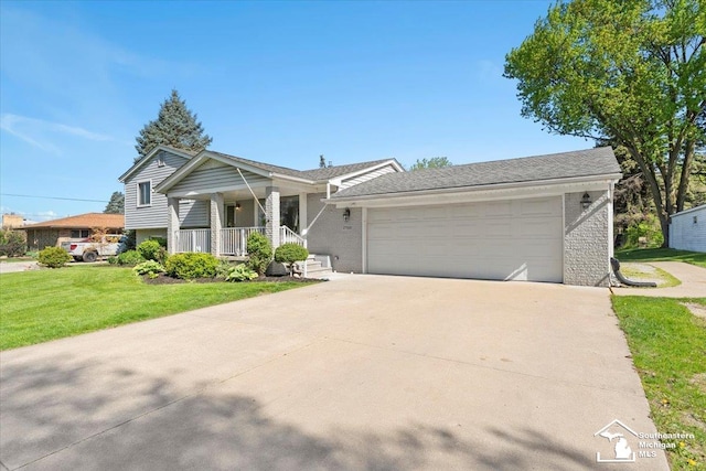 split level home with a front lawn, a garage, concrete driveway, and a porch