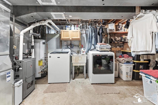 washroom featuring water heater, separate washer and dryer, and cabinet space