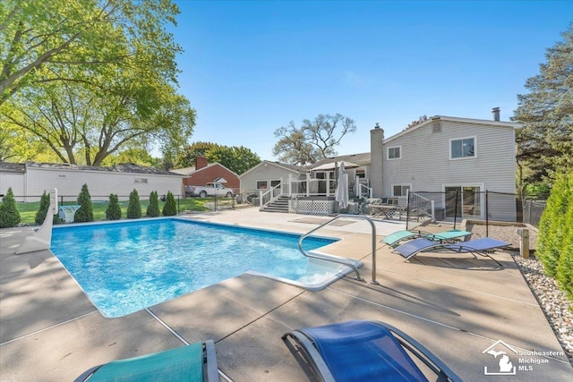 view of swimming pool featuring a patio area, fence, and a wooden deck