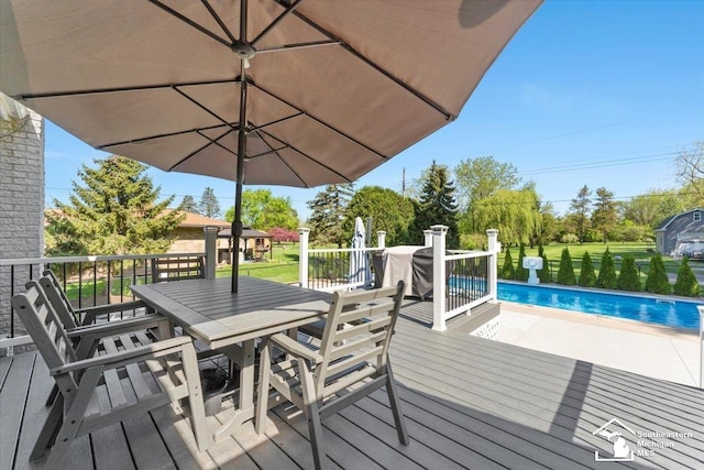 wooden deck featuring an outdoor pool, outdoor dining space, and a patio