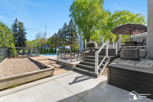view of patio featuring an outdoor pool, a wooden deck, stairway, and central AC unit