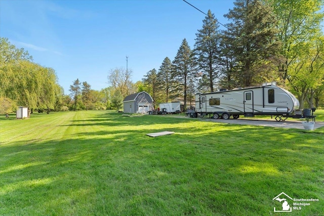 view of green lawn with an outbuilding and a shed