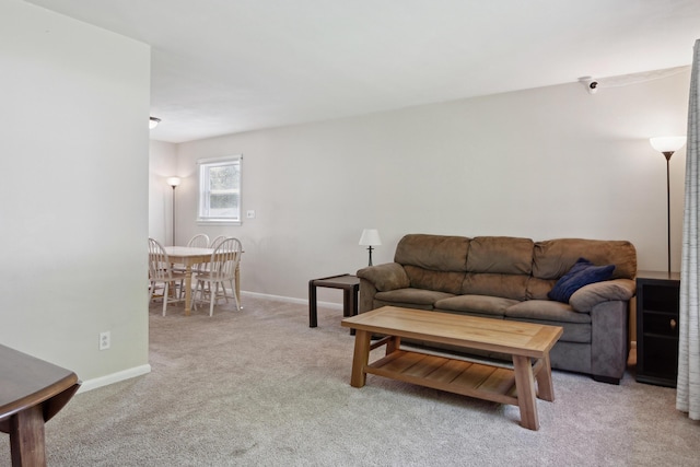living area with light colored carpet and baseboards