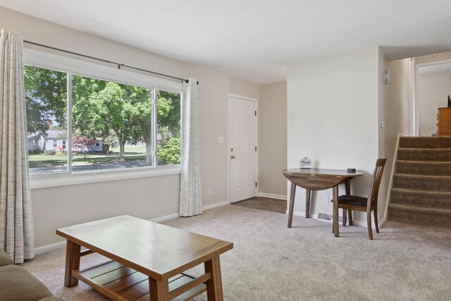 sitting room with carpet flooring, stairway, and baseboards