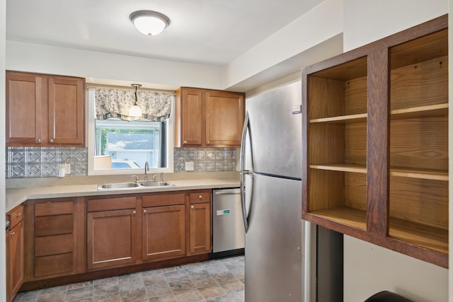 kitchen featuring appliances with stainless steel finishes, a sink, open shelves, brown cabinets, and decorative backsplash
