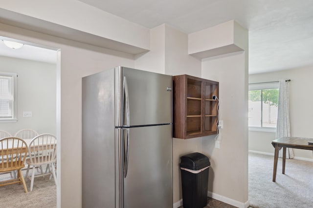 kitchen featuring freestanding refrigerator, carpet, and baseboards
