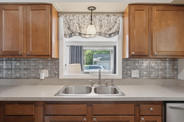 kitchen featuring a sink, brown cabinets, decorative backsplash, and light countertops