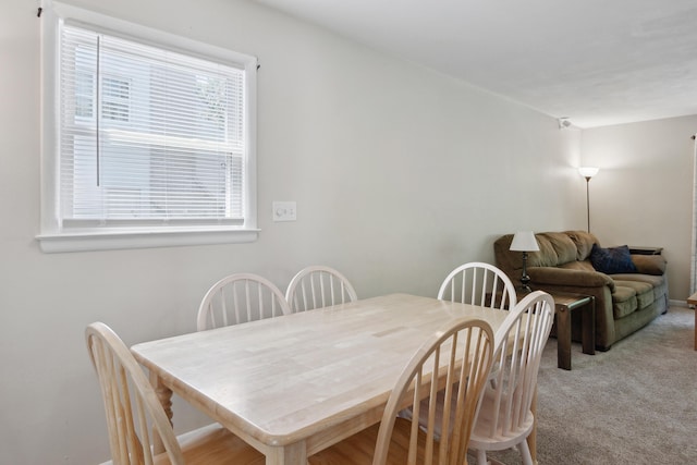 dining space with plenty of natural light, light carpet, and baseboards