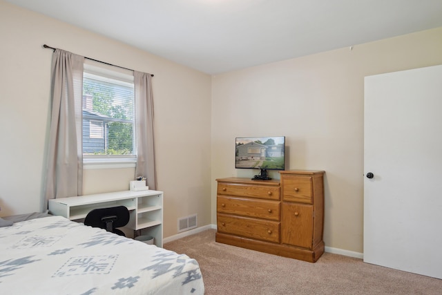bedroom with light colored carpet and baseboards