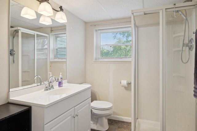 full bath with a stall shower, toilet, vanity, and baseboards