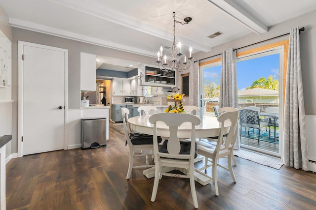 dining area with a chandelier, beamed ceiling, and dark wood-style flooring