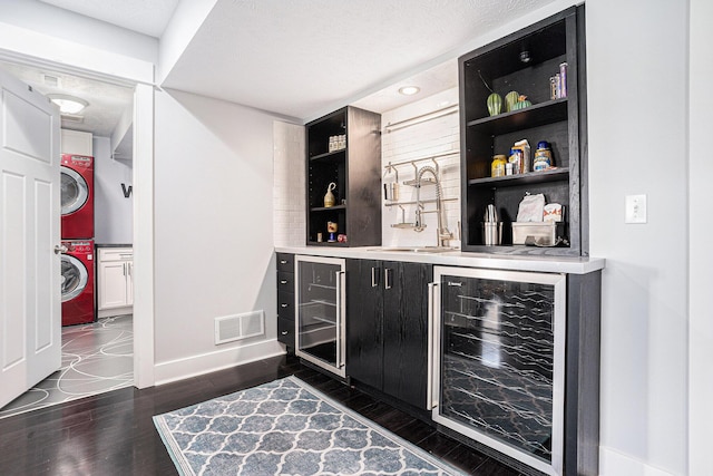 3080 Silver Fir Ct, Holland, MI 49424 - indoor bar with wine cooler, stacked washer / drying machine, baseboards, and dark wood-style floors