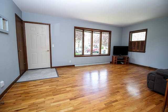 6339 Westchester St, Portage, MI 49024 - unfurnished living room with a baseboard radiator, light wood-type flooring, and baseboards