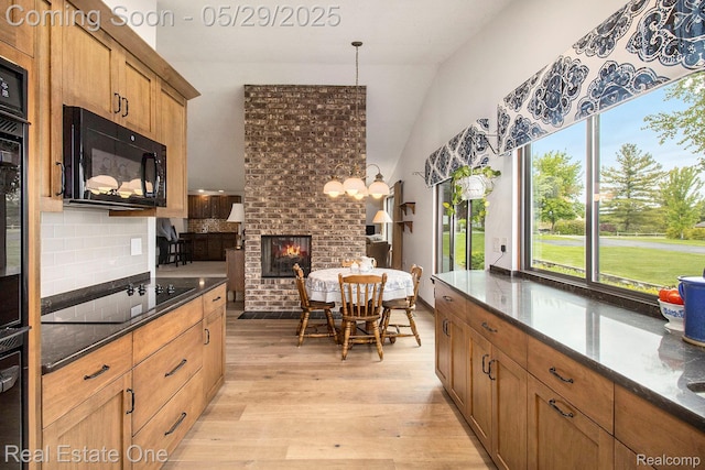 4976 Ledgewood Dr, Commerce Twp, MI 48382 - kitchen with black appliances, light wood-style floors, lofted ceiling, backsplash, and dark stone countertops