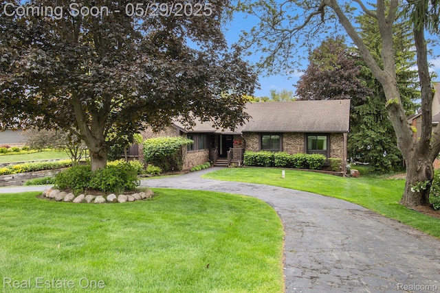 4976 Ledgewood Dr, Commerce Twp, MI 48382 - view of front of home featuring a front lawn, a shingled roof, and brick siding
