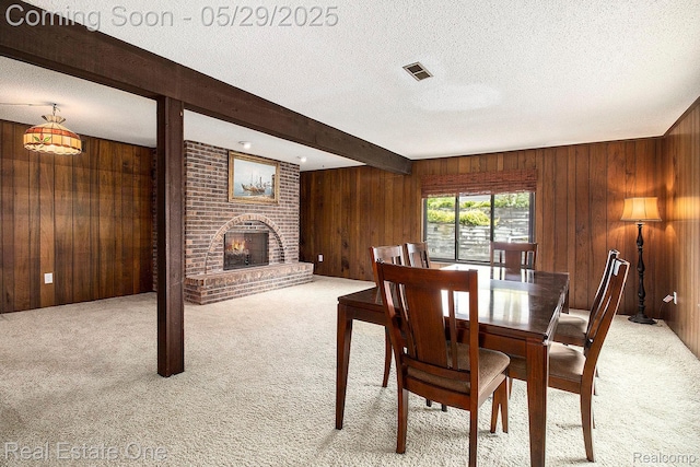 4976 Ledgewood Dr, Commerce Twp, MI 48382 - dining area featuring wood walls, light colored carpet, beamed ceiling, a fireplace, and a textured ceiling