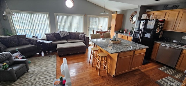 8889 Anchor Bay Dr, Clay, MI 48001 - kitchen with open floor plan, stainless steel dishwasher, dark wood finished floors, a kitchen bar, and lofted ceiling