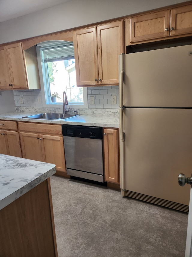 501 Virginia Ave, East Lansing, MI 48823 - kitchen featuring freestanding refrigerator, stainless steel dishwasher, a sink, decorative backsplash, and light countertops