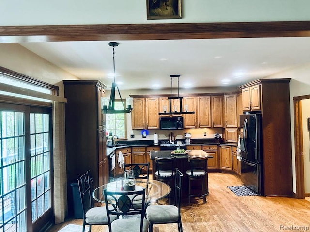 3217 Autumn View Ln, Metamora, MI 48455 - kitchen with black appliances, dark countertops, light wood-style floors, a sink, and a kitchen island