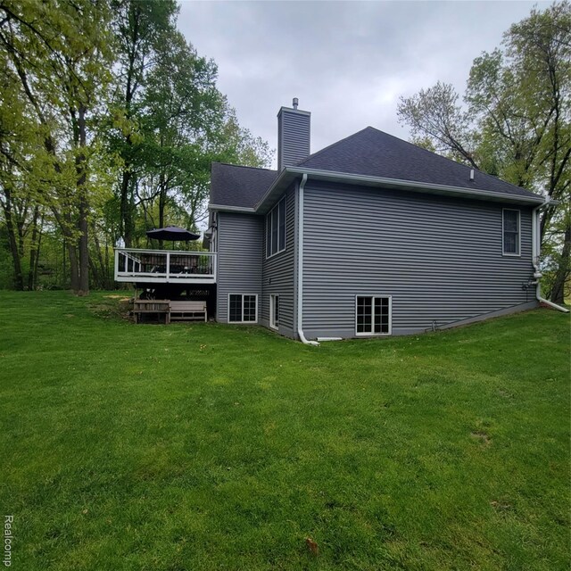 3217 Autumn View Ln, Metamora, MI 48455 - rear view of house with a wooden deck, a chimney, and a lawn
