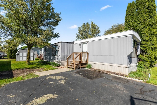 351 N Squirrel Rd, Auburn Hills, MI 48326 - manufactured / mobile home with a storage unit, an outdoor structure, and a front yard