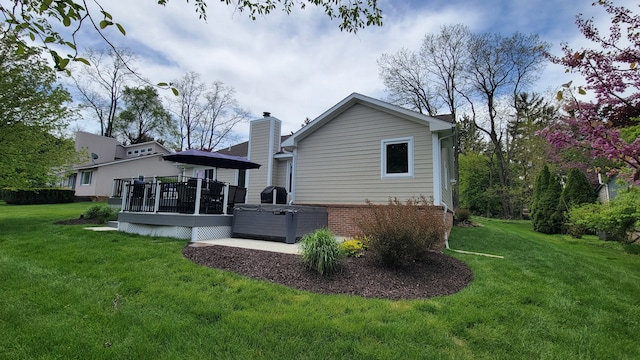 6192 N Shore Dr, West Bloomfield, MI 48324 - back of house with a wooden deck, a lawn, brick siding, and a chimney