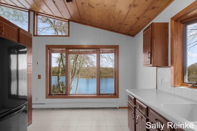 16972 James Dr, Big Rapids, MI 49307 - kitchen with freestanding refrigerator, lofted ceiling, light countertops, wood ceiling, and a water view
