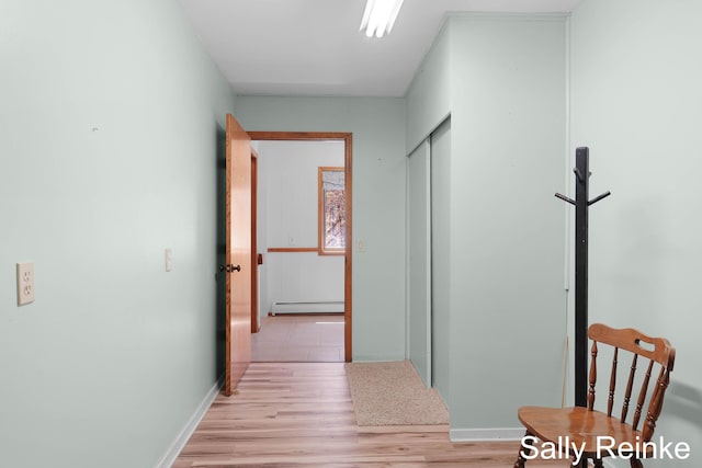 16972 James Dr, Big Rapids, MI 49307 - hall featuring a baseboard radiator, light wood-style flooring, and baseboards