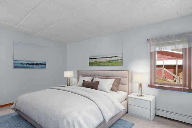 16972 James Dr, Big Rapids, MI 49307 - carpeted bedroom with a baseboard radiator, a paneled ceiling, and baseboards