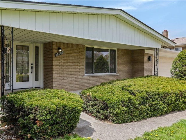 37305 Maas Dr, Sterling Heights, MI 48312 - view of front facade with a garage, brick siding, and covered porch