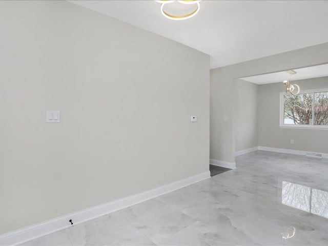 37305 Maas Dr, Sterling Heights, MI 48312 - empty room featuring a chandelier, light marble finish floors, and baseboards