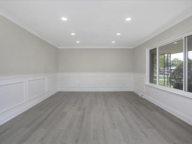 37305 Maas Dr, Sterling Heights, MI 48312 - spare room featuring crown molding, recessed lighting, wainscoting, light wood-style floors, and a decorative wall