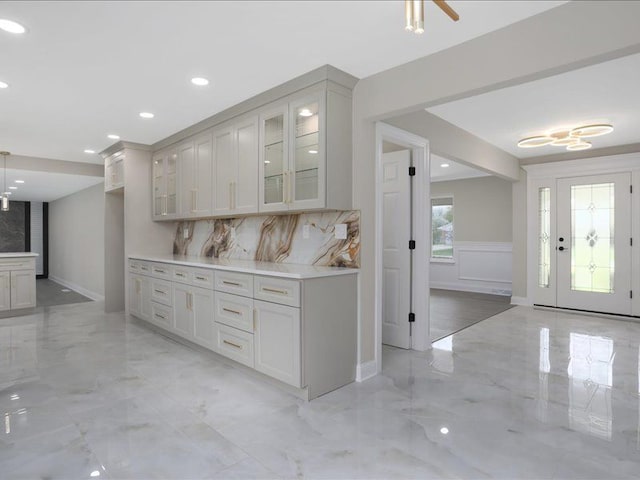 37305 Maas Dr, Sterling Heights, MI 48312 - kitchen with light marble finish floors, tasteful backsplash, glass insert cabinets, recessed lighting, and light countertops