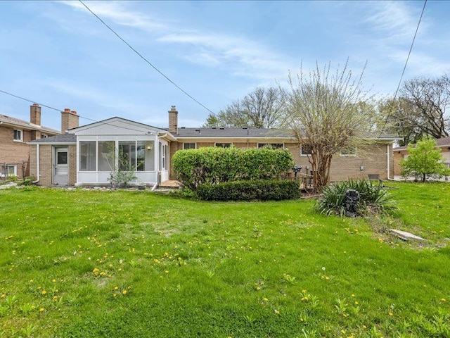 37305 Maas Dr, Sterling Heights, MI 48312 - rear view of house featuring a sunroom, a yard, and brick siding