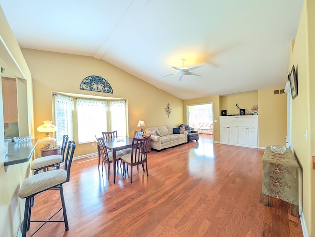 dining room with wood finished floors, lofted ceiling, a ceiling fan, and baseboards