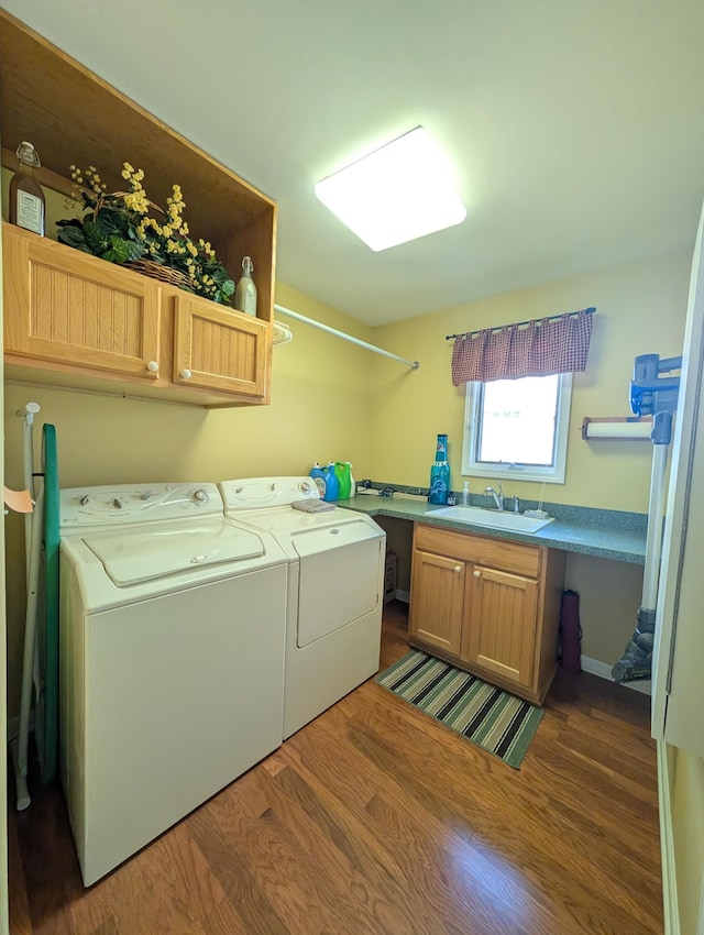 clothes washing area featuring cabinet space, independent washer and dryer, and wood finished floors