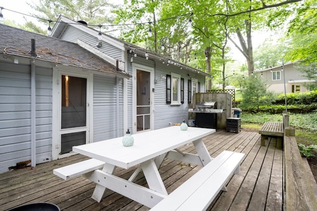 deck with outdoor dining space and a grill