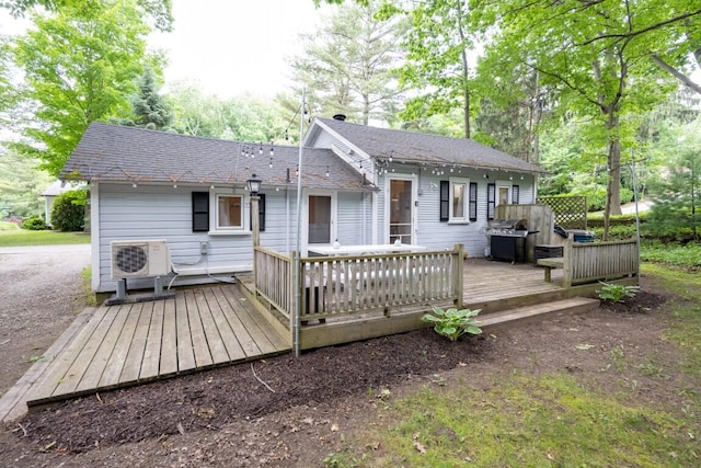 back of house featuring ac unit, a shingled roof, and a deck