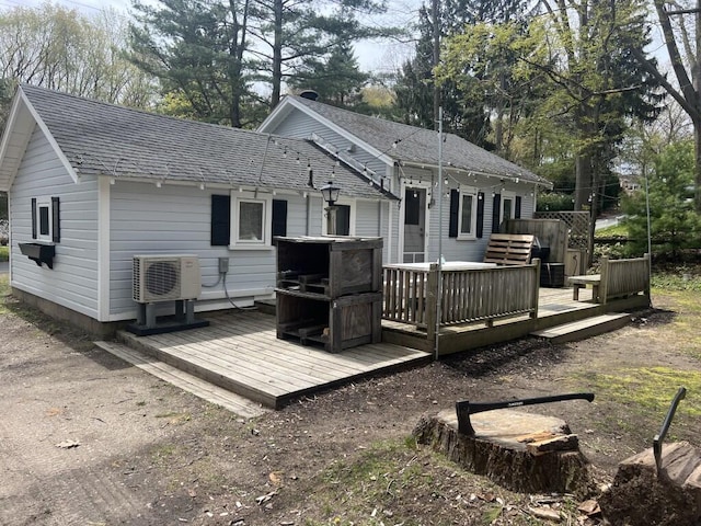 back of house featuring ac unit, a wooden deck, and roof with shingles