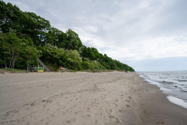 view of dirt / gravel road featuring view of water and beach