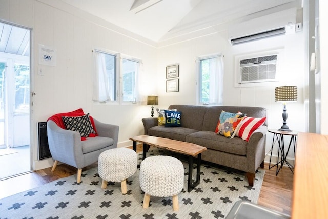 living room featuring a wall mounted air conditioner, wood finished floors, and vaulted ceiling
