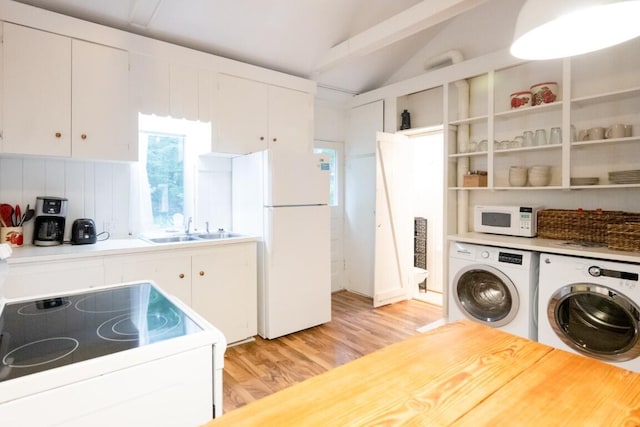 kitchen featuring white appliances, a sink, light wood-style floors, independent washer and dryer, and lofted ceiling