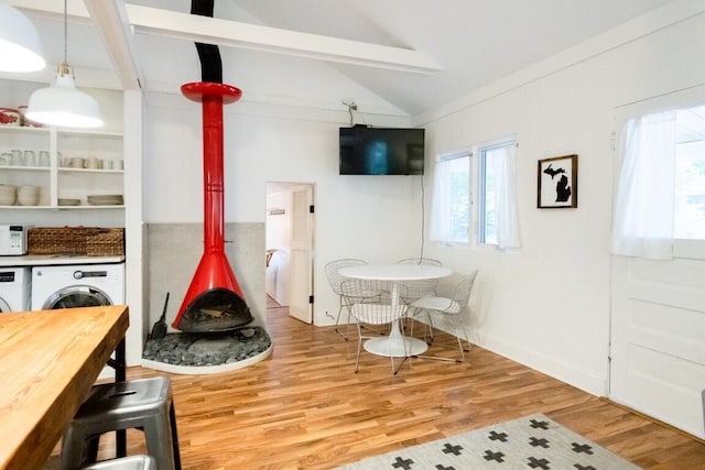 rec room featuring a wood stove, washing machine and dryer, and wood finished floors