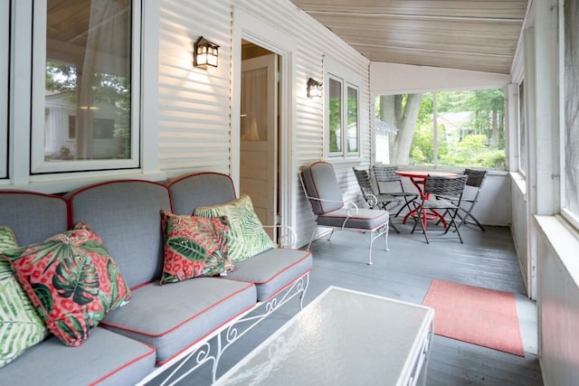 sunroom / solarium with lofted ceiling, wood finished floors, and wood ceiling
